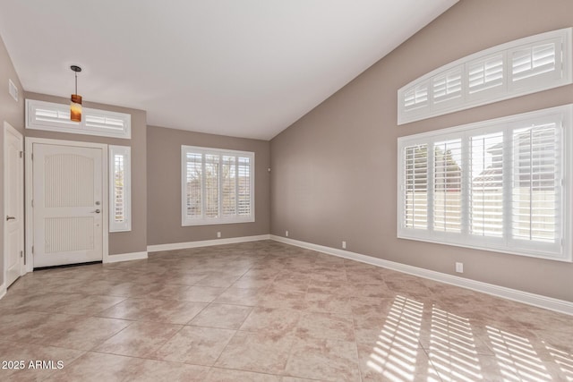 entrance foyer with light tile patterned floors, baseboards, and lofted ceiling