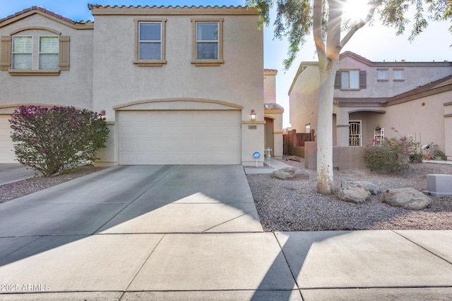 mediterranean / spanish-style home featuring a garage, concrete driveway, and stucco siding