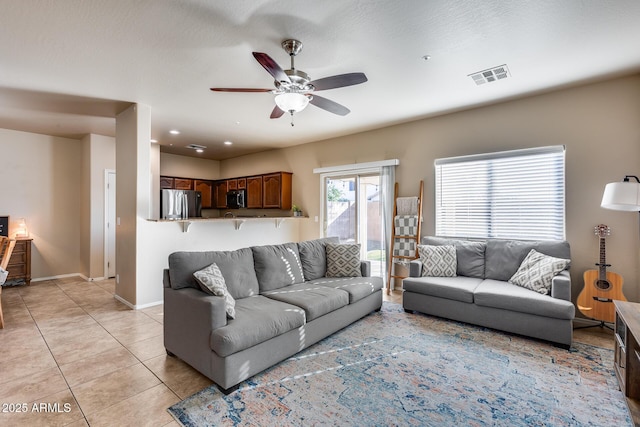 living area featuring light tile patterned floors, baseboards, visible vents, a ceiling fan, and recessed lighting