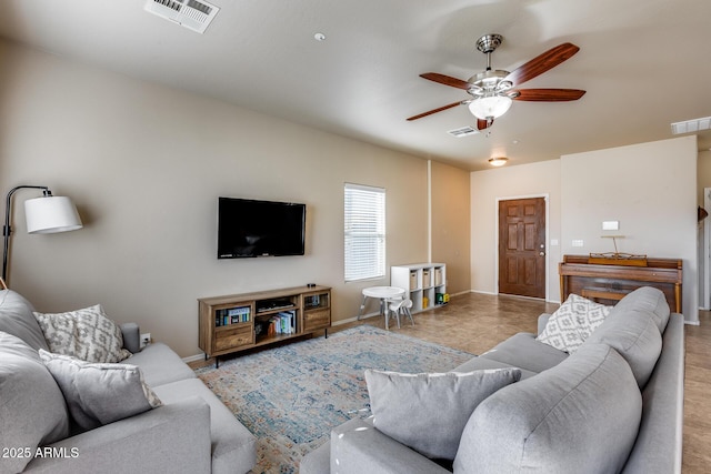 living room featuring ceiling fan, visible vents, and baseboards