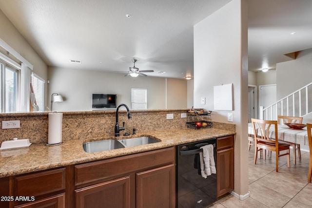 kitchen featuring visible vents, dishwasher, brown cabinets, light stone countertops, and a sink