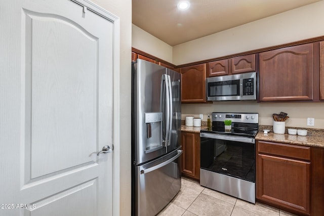 kitchen featuring light stone countertops, light tile patterned floors, and appliances with stainless steel finishes