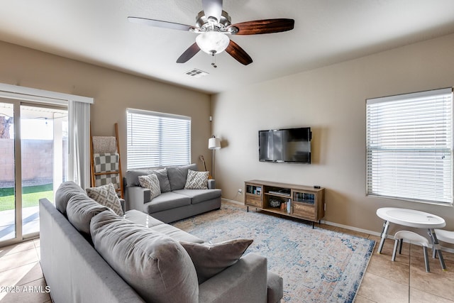 living room featuring light tile patterned floors, baseboards, visible vents, and ceiling fan