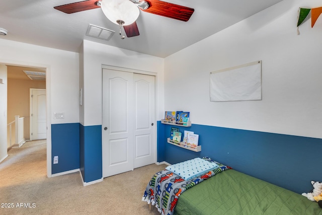 carpeted bedroom with ceiling fan, a closet, visible vents, and baseboards