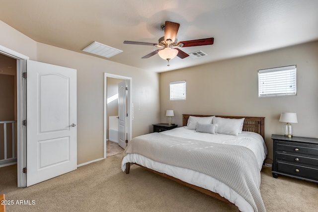 carpeted bedroom featuring a ceiling fan, visible vents, baseboards, and ensuite bathroom