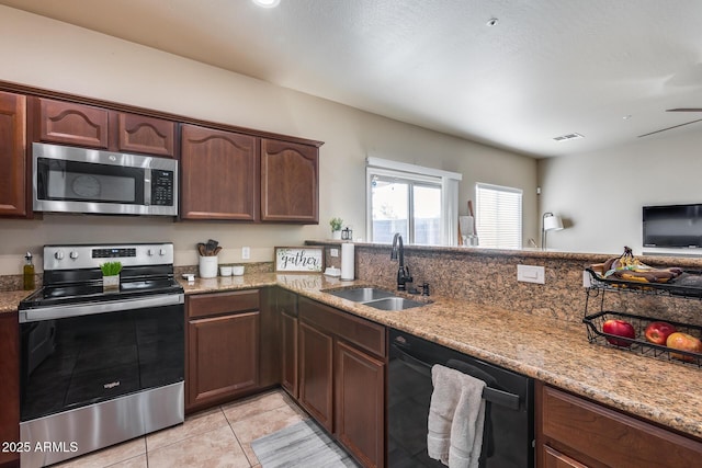 kitchen featuring light stone counters, visible vents, appliances with stainless steel finishes, light tile patterned flooring, and a sink