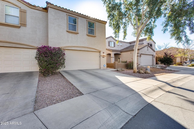 mediterranean / spanish house featuring concrete driveway, a tiled roof, and stucco siding