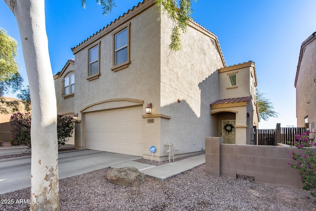 mediterranean / spanish-style home with a garage, a tile roof, fence, and stucco siding