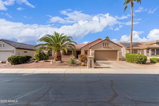 view of front of house with stucco siding, driveway, a tile roof, and a garage