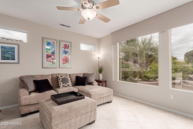 living area with light tile patterned floors, visible vents, baseboards, and ceiling fan