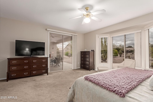 bedroom featuring access to exterior, baseboards, light carpet, and a ceiling fan