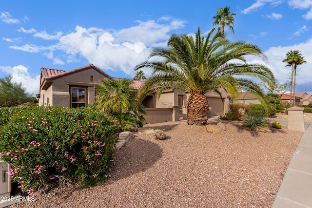 view of front of property with stucco siding, a garage, and a tiled roof