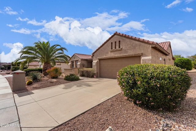 mediterranean / spanish-style house featuring a tile roof, stucco siding, concrete driveway, and a garage