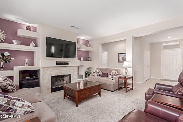 living area with baseboards, visible vents, built in shelves, and a brick fireplace