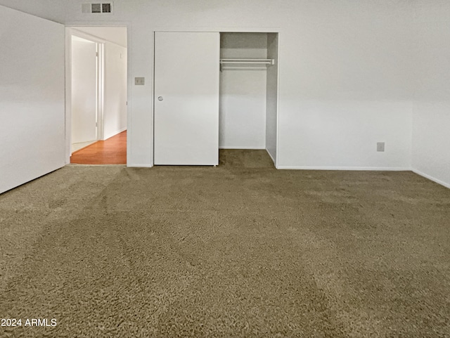 unfurnished bedroom featuring carpet floors and a closet