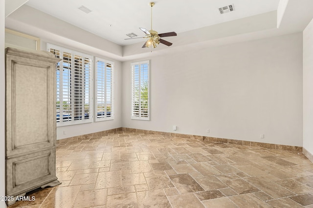 11986 N 134th Pl, Scottsdale, AZ 85259 - unfurnished room featuring stone tile flooring, a ceiling fan, a tray ceiling, and baseboards