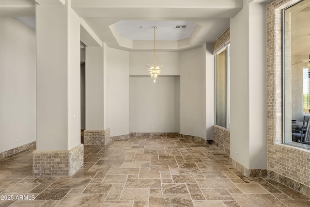 11986 N 134th Pl, Scottsdale, AZ 85259 - empty room featuring stone tile floors, a tray ceiling, and a chandelier