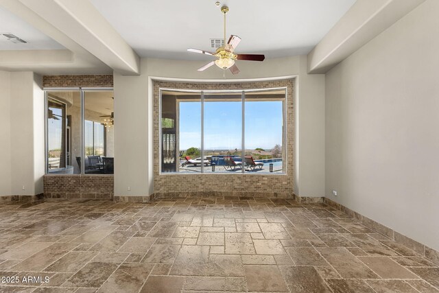 11986 N 134th Pl, Scottsdale, AZ 85259 - empty room with stone tile flooring, healthy amount of natural light, ceiling fan, and baseboards