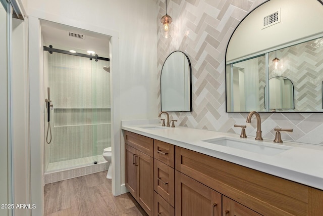 7710 E Gainey Ranch Rd Unit 142, Scottsdale, AZ 85258 - full bathroom featuring double vanity, toilet, a stall shower, tasteful backsplash, and wood finished floors