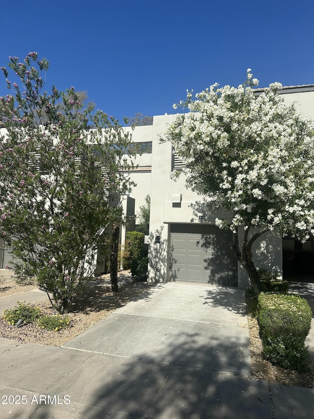7710 E Gainey Ranch Rd Unit 142, Scottsdale, AZ 85258 - view of front of home with stucco siding, concrete driveway, and an attached garage