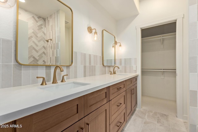 7710 E Gainey Ranch Rd Unit 142, Scottsdale, AZ 85258 - bathroom with double vanity, a walk in closet, and decorative backsplash