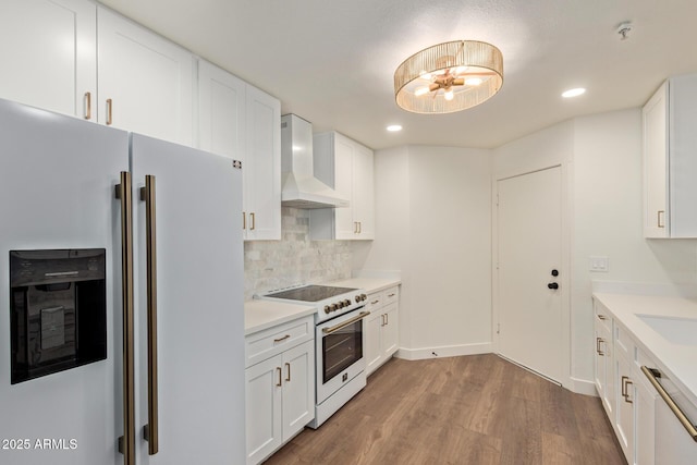 7710 E Gainey Ranch Rd Unit 142, Scottsdale, AZ 85258 - kitchen with white appliances, wall chimney exhaust hood, wood finished floors, tasteful backsplash, and white cabinetry