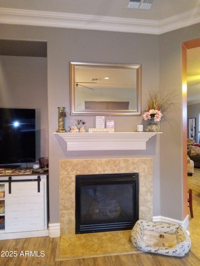 interior details with a premium fireplace, wood finished floors, and crown molding