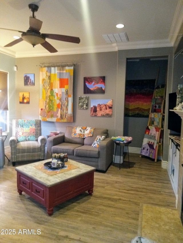 living room with visible vents, crown molding, ceiling fan, and wood finished floors