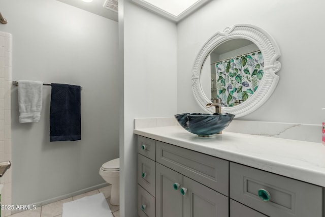 bathroom featuring toilet, vanity, and tile patterned flooring