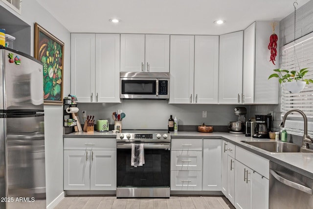6739 N 16th St Unit 14, Phoenix, AZ 85016 - kitchen featuring appliances with stainless steel finishes, white cabinetry, light wood-style flooring, light countertops, and recessed lighting
