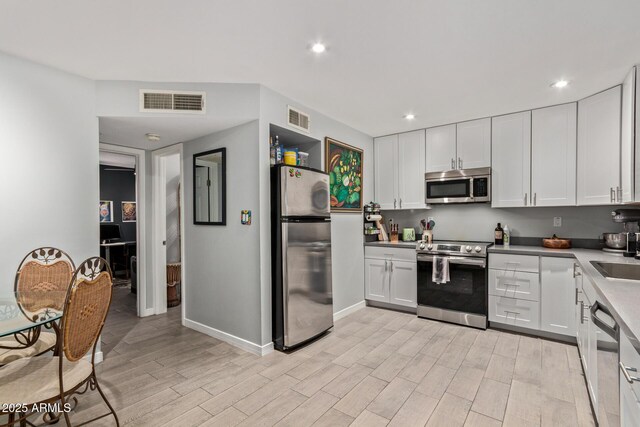 6739 N 16th St Unit 14, Phoenix, AZ 85016 - kitchen featuring appliances with stainless steel finishes, light wood-style floors, white cabinets, and recessed lighting
