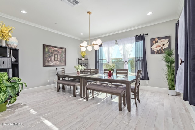 dining room featuring crown molding, a notable chandelier, and light hardwood / wood-style flooring