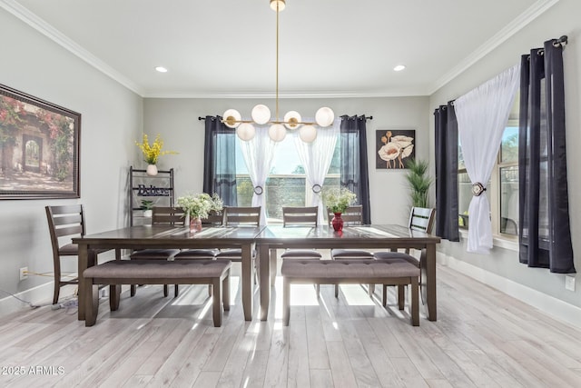 dining room featuring crown molding, a healthy amount of sunlight, a notable chandelier, and light hardwood / wood-style flooring