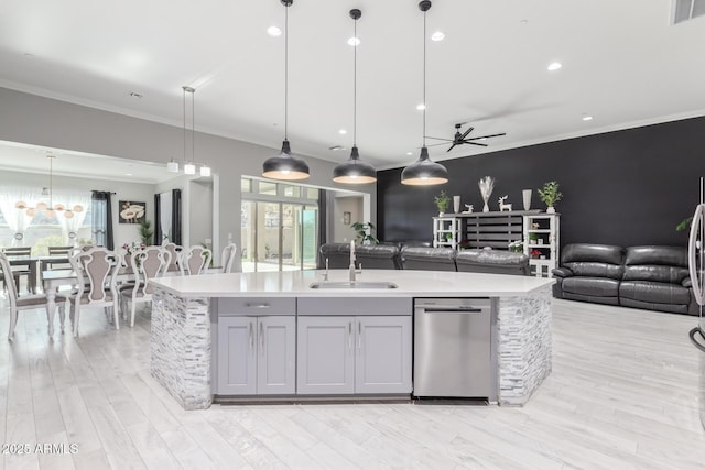 kitchen with sink, gray cabinets, an island with sink, decorative light fixtures, and stainless steel dishwasher