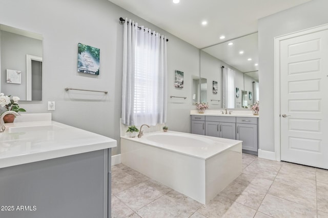 bathroom with vanity, a tub, and tile patterned floors