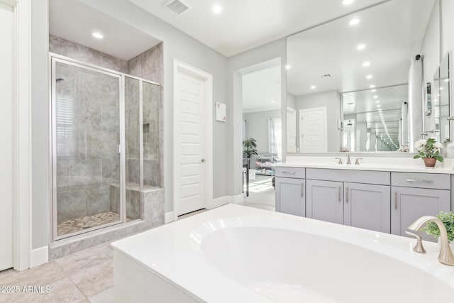 bathroom featuring shower with separate bathtub, vanity, and tile patterned floors