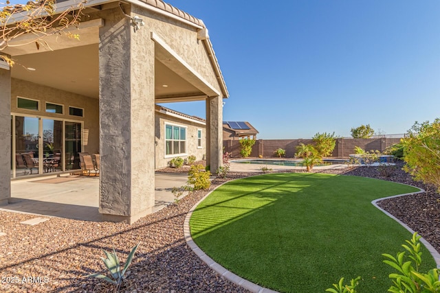 view of yard with a fenced in pool and a patio