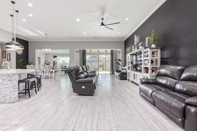 living room with sink, ornamental molding, light hardwood / wood-style floors, and ceiling fan