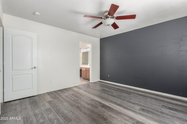 unfurnished bedroom featuring ceiling fan, connected bathroom, and dark hardwood / wood-style flooring