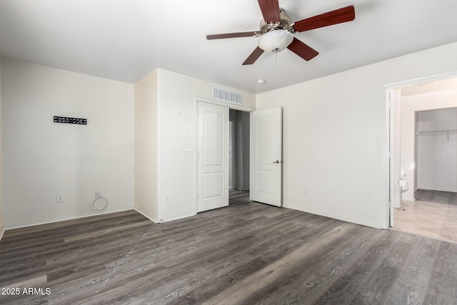 unfurnished bedroom with ceiling fan, connected bathroom, and dark hardwood / wood-style flooring