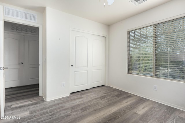 unfurnished bedroom with hardwood / wood-style floors and a closet