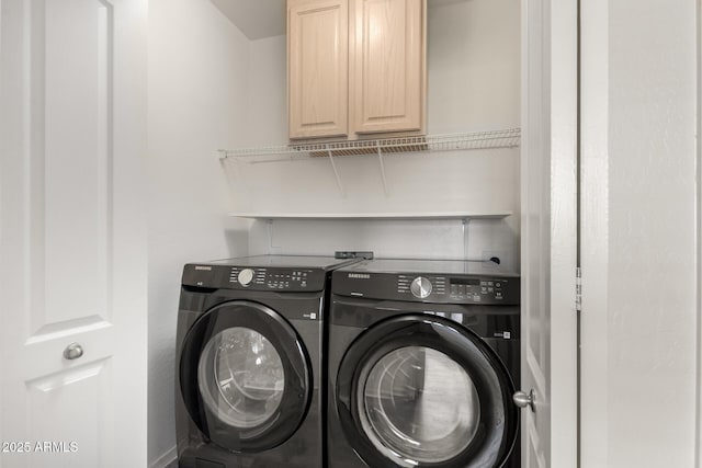 washroom featuring separate washer and dryer and cabinets