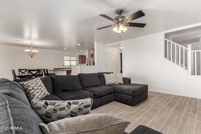 living room with ceiling fan with notable chandelier