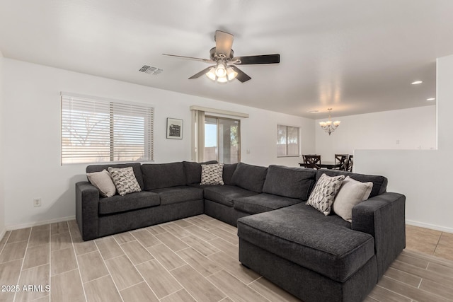 living room with ceiling fan with notable chandelier