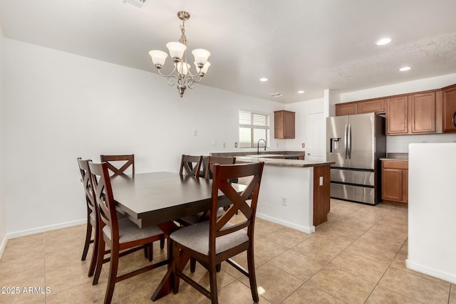 tiled dining area featuring a notable chandelier and sink