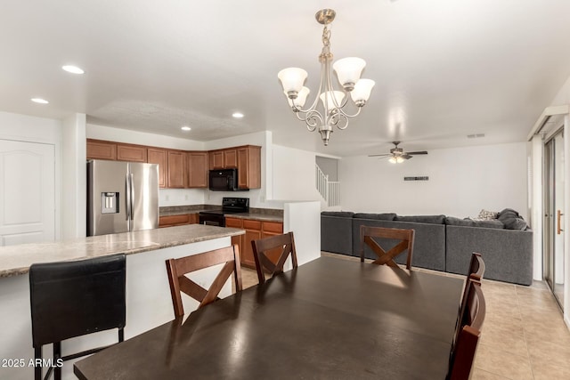 dining space featuring ceiling fan with notable chandelier and light tile patterned floors