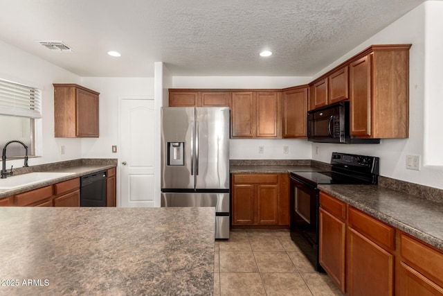 kitchen featuring light tile patterned floors, sink, a textured ceiling, and black appliances