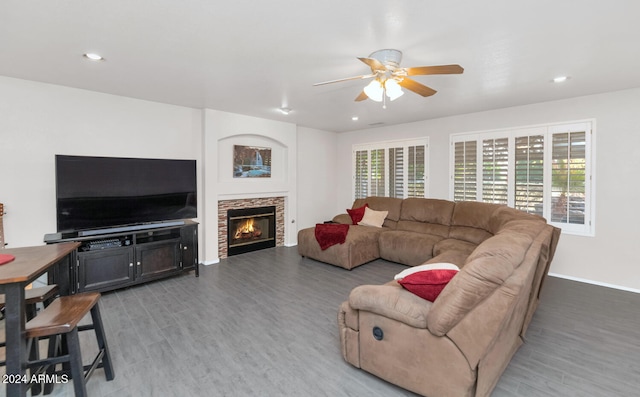 living room featuring hardwood / wood-style floors, a stone fireplace, and ceiling fan