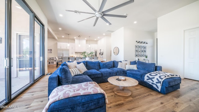 living room with ceiling fan and light hardwood / wood-style flooring