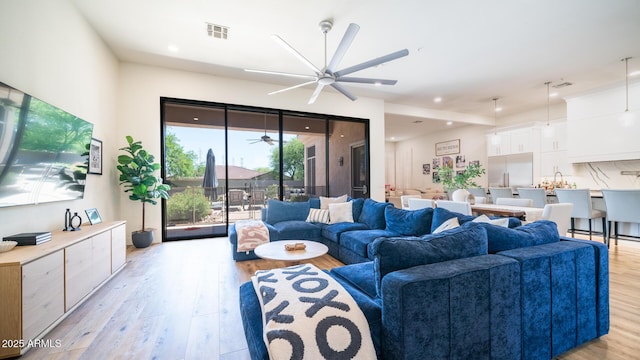 living room featuring ceiling fan and light hardwood / wood-style flooring